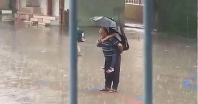 Baba yağışın altında nəvəsini kürəyinə alıb İstiqlal Marşını oxudu