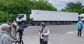 Jurnalistlər cəsədlərlə dolu yük maşınlarının YANINDA