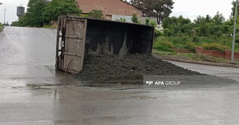 Gəncədə Kamazın qoşqusu aşıb, yük yerindəki qum yola dağılıb
