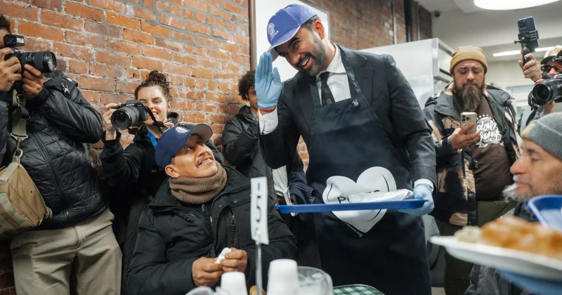 Мэр Нью Йорка подает еду в столовой в Бронксе объектив