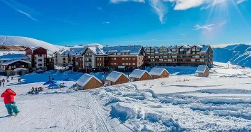Xizək kurortunda üzərində Rusiya yazısı olan gödəkçə geyinmiş turist...