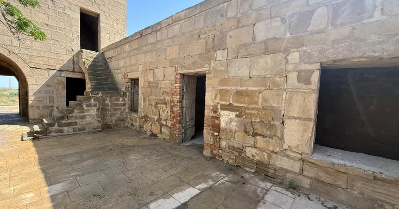 Tarixi karvansaranın üzərindəki yazıları qum sementlə örtüblər Fotolar