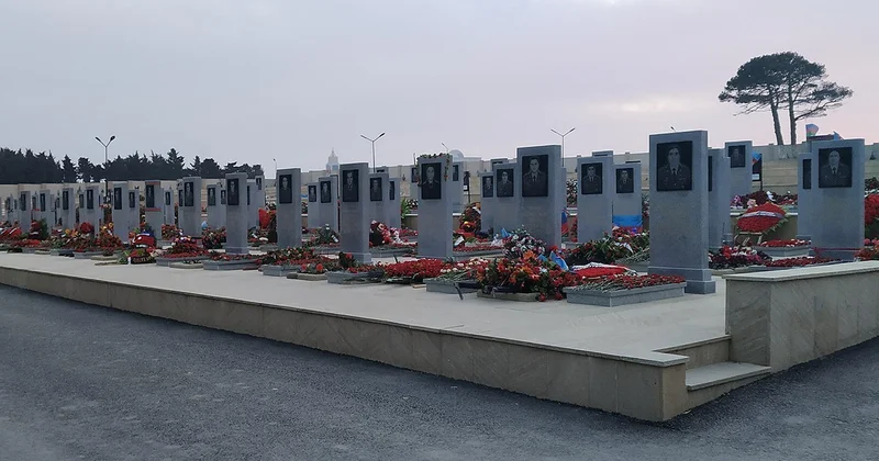 Люди посещают Военно мемориальное кладбище, чтобы почтить память шехидов Отечественной войны