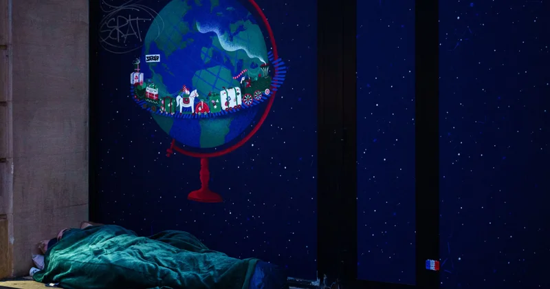 Бездомный спит на улице в морозном Париже объектив