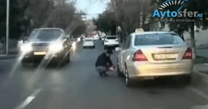 Yolun ortasında təkər təmir edən sürücü ölümə özü can atır VİDEO